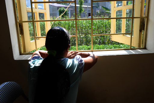 A woman looking out from a window at a centre for trafficked women in the northern city of Lao Cai