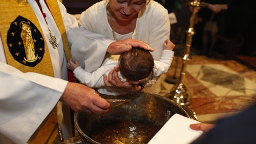 Criança recebe o Batismo na Catedral de Notre Dame de Paris. &#8211; fr