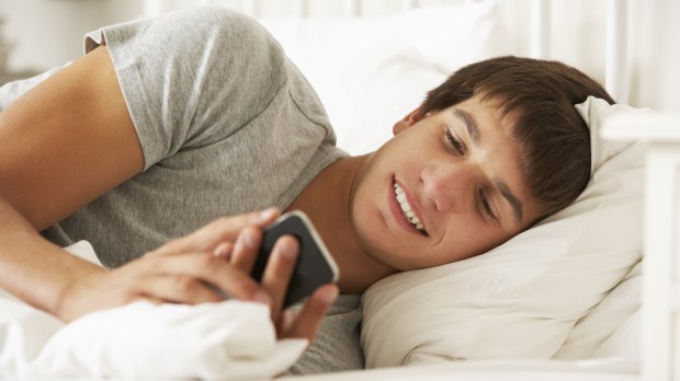 WEB BED BOY PHONE TEXTING © Monkey Business Images Shutterstock