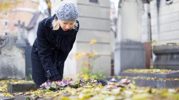 Femme pleurant devant une tombe