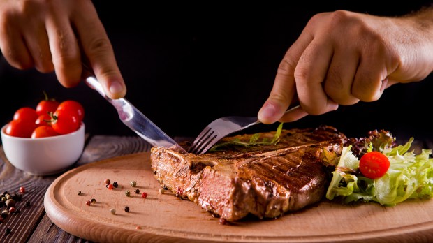 eating stake from plate with fork and knife man hands &#8211; shutterstock_487799251