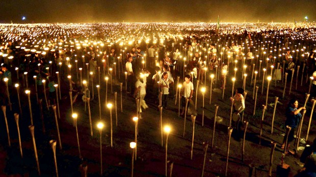 Volunteers light candles during the &#8220;Light of Peace in the Phili