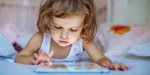 PETITE FILLE DEVANT UNE TABLETTE