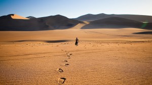 WALKING ALONE IN THE DESERT WITH FOOTSTEPS