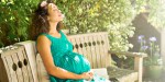 PREGNANT WOMAN SITTING IN PARK