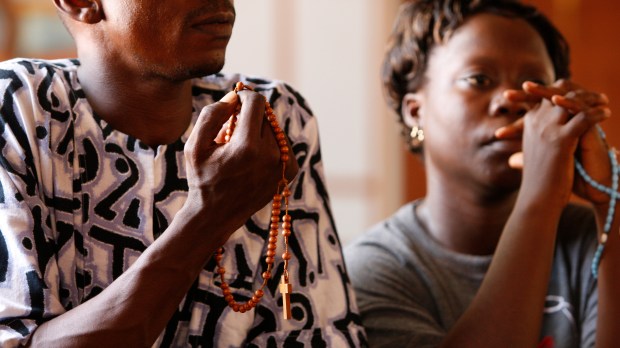 Couple africain priant le rosaire.