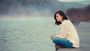 GIRL SITTING BY LAKE