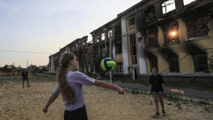 Gra w siatkówkę przed budynkiem zniszczonej szkoły w Charkowie, czerwiec 2022 r.