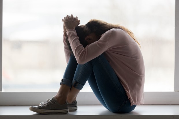 Depressed sad teen girl sit on sill crying alone at home upset desperate young woman feeling frustrated anxious regret mistake suffer from unwanted teenage pregnancy abortion problem concept