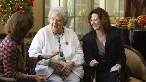 The Rosary Team members praying the rosary with an elder care patient