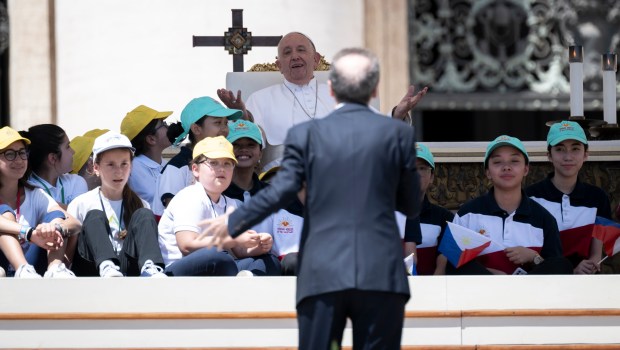 Pope Francis (up) listens to a speech by Italian film director Roberto Benigni during a mass on World Children's Day at St Peter's Basilica in the Vatican on May 26, 2024.