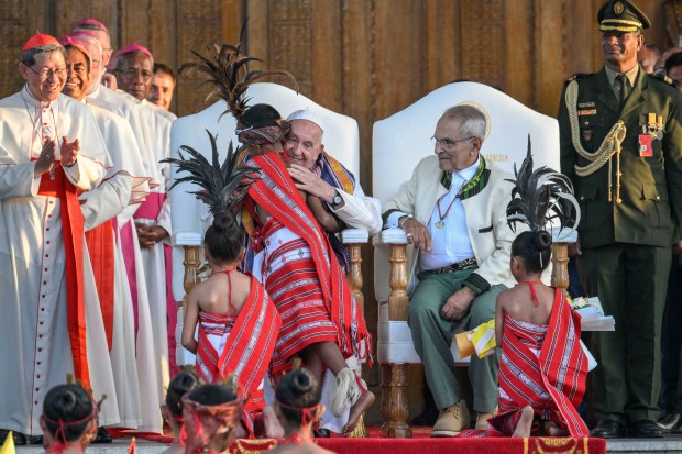 Pope Francis hugs a child alongside East Timor President's Jose Ramos-Horta (3R) during a welcoming ceremony at the Presidential Palace in Dili.
